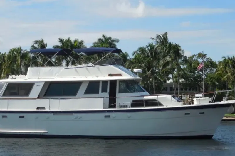 The Image of 1981 Hatteras 56 Motor Yacht on water, surrounded by palm trees. - 0