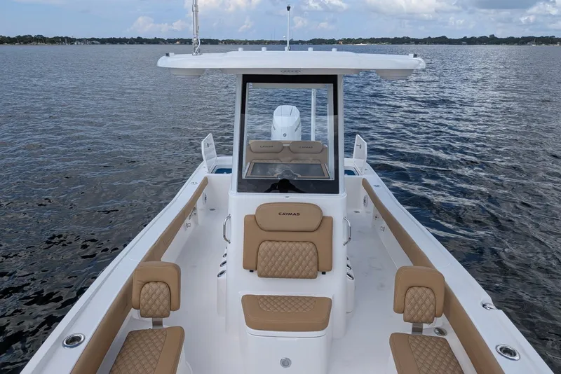 Slide: The Image of 2027 Caymas 28 HB boat on calm water, featuring tan seating and sleek design. - 4