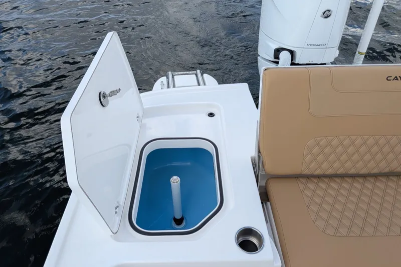 Slide: The Image of 2027 Caymas 28 HB boat with open storage compartment and tan seating. - 11