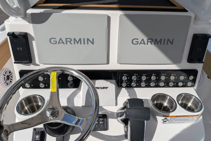 Slide: The Image of 2027 Caymas 28 HB boat dashboard with dual Garmin displays and Mercury controls. - 7