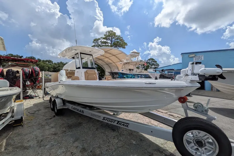 Slide: The Image of 2027 Caymas 28 HB boat on trailer under a cloudy sky. - 1
