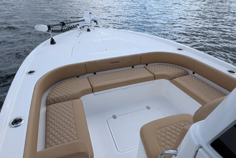 Slide: The Image of 2027 Caymas 28 HB boat with tan cushioned seating on calm water. - 14