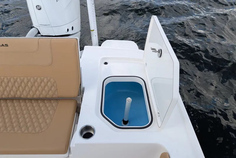Slide: The Image of 2027 Caymas 28 HB boat with open storage compartment and tan seating. - 13