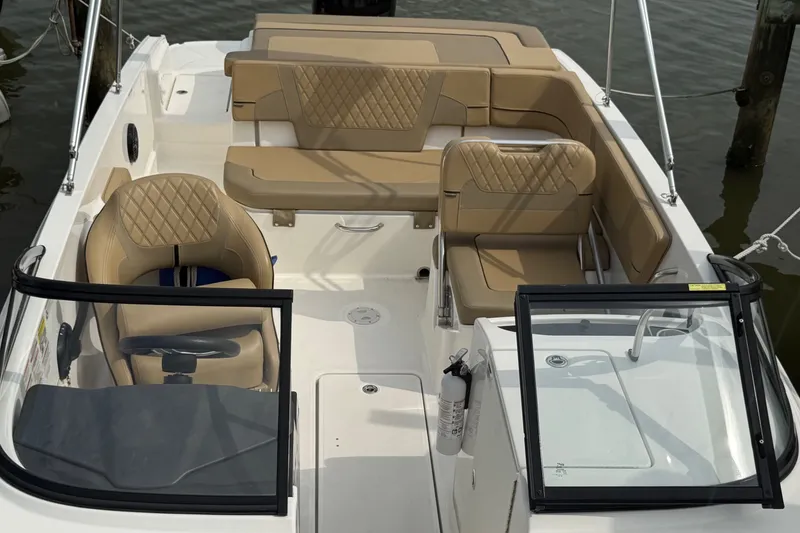 Slide: The Image of 2025 Bayliner VR6 Bowrider OB interior with tan seating and steering wheel. - 6