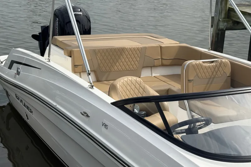 Slide: The Image of 2025 Bayliner VR6 Bowrider OB with tan seating, docked on calm water. - 7