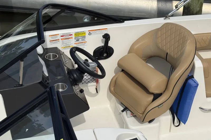 Slide: The Image of 2025 Bayliner VR6 Bowrider OB cockpit with tan seating and steering wheel. - 8