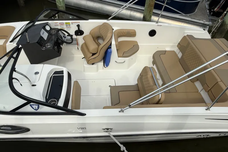Slide: The Image of 2025 Bayliner VR6 Bowrider OB with tan seating and modern dashboard, docked at marina. - 4