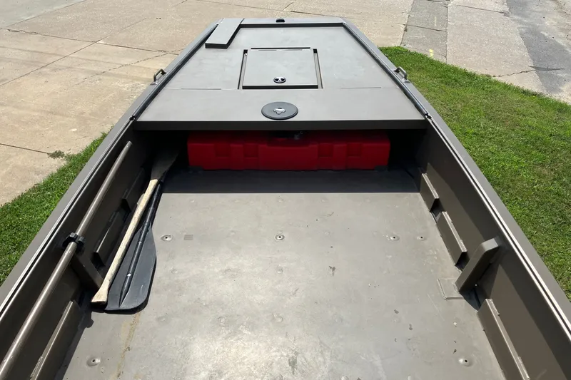 Slide: The Image of 2017 Pro-Drive SBX Series 18' boat interior with storage compartment and paddle. - 13