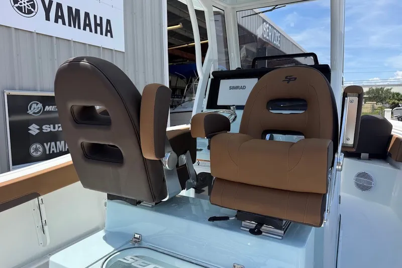 Slide: The Image of 2027 Sea Pro 245FLXR Sandbar boat interior with brown seating and navigation equipment. - 21