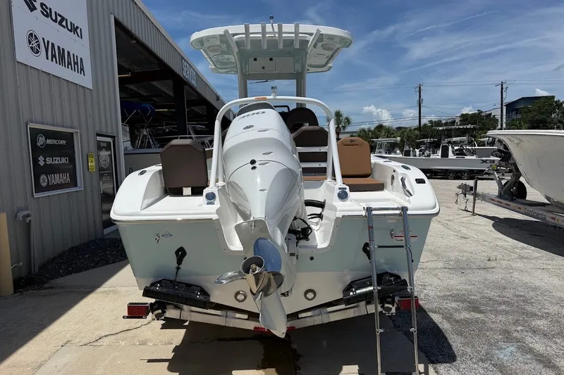 Slide: The Image of 2027 Sea Pro 245FLXR Sandbar boat at dealership with outboard motor and ladder. - 9