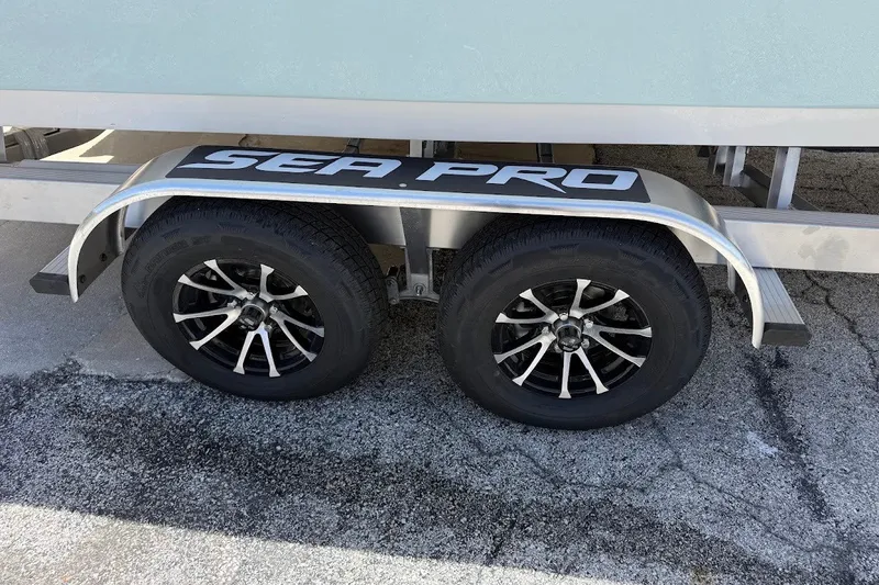 Slide: The Image of Trailer wheels of 2027 Sea Pro 245FLXR Sandbar boat on pavement. - 5