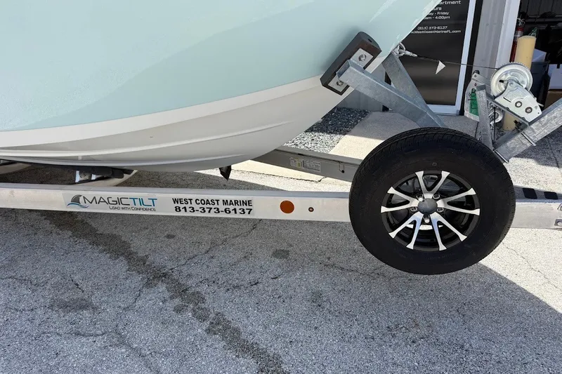 Slide: The Image of Trailer carrying a 2027 Sea Pro 245FLXR Sandbar boat, featuring Magic Tilt branding. - 2