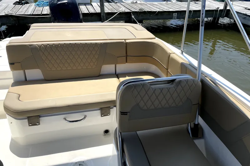 Slide: The Image of 2025 Bayliner VR6 Bowrider OB interior with tan seating at dock. - 6