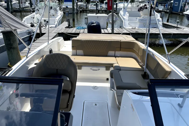 Slide: The Image of 2025 Bayliner VR6 Bowrider OB with spacious seating at a marina dock. - 4