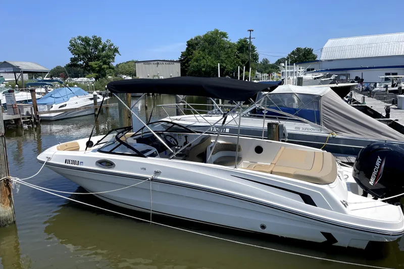 The Image of 2025 Bayliner VR6 Bowrider OB docked at marina, featuring sleek design and Mercury outboard engine. - 1