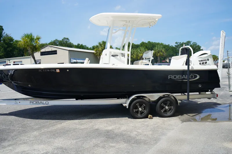 The Image of 2019 Robalo 246 Cayman boat on trailer with Yamaha engine, parked outdoors. - 0