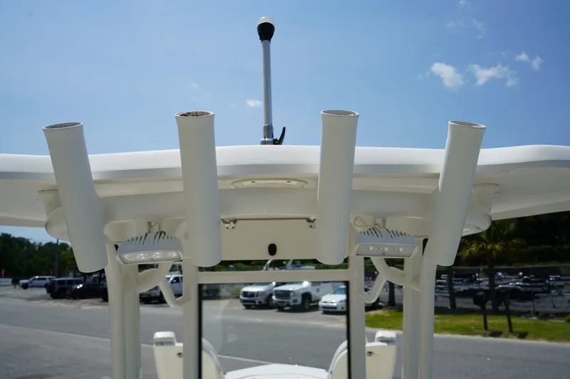 Slide: The Image of 2019 Robalo 246 Cayman boat with rod holders and T-top against blue sky. - 17