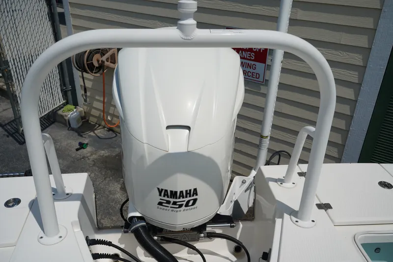 Slide: The Image of 2019 Robalo 246 Cayman boat with Yamaha 250 engine, docked near a fence. - 13