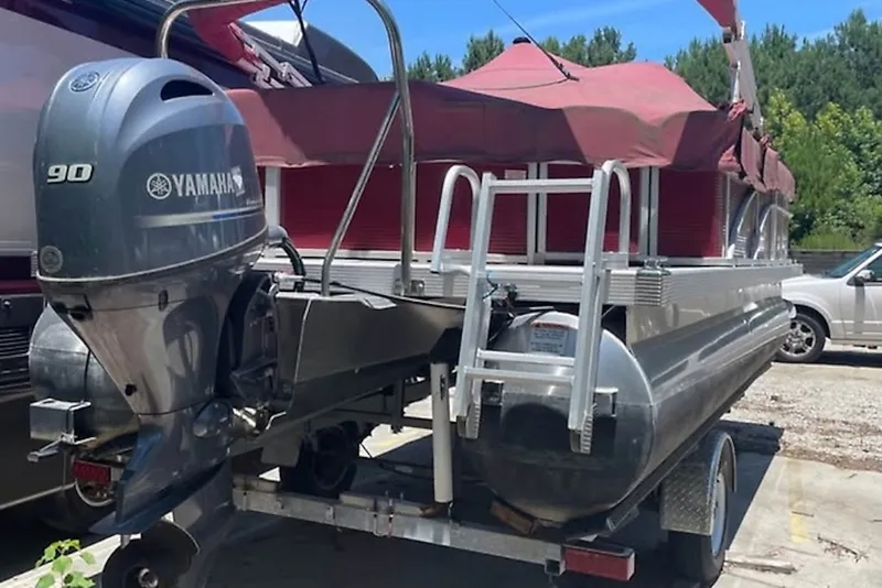 Slide: The Image of 2021 Bennington 205E pontoon boat with Yamaha 90 engine, covered and on trailer. - 4