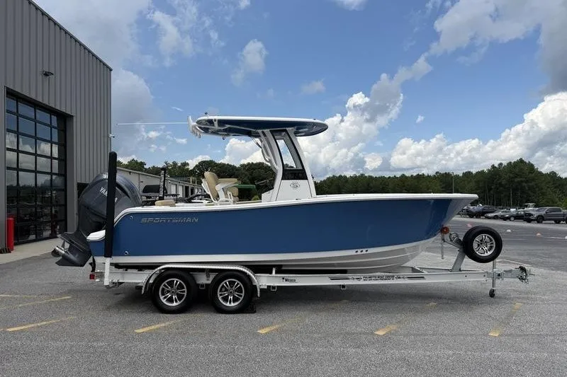 The Image of 2025 Sportsman Open 212 Center Console boat on trailer, parked outdoors. - 1