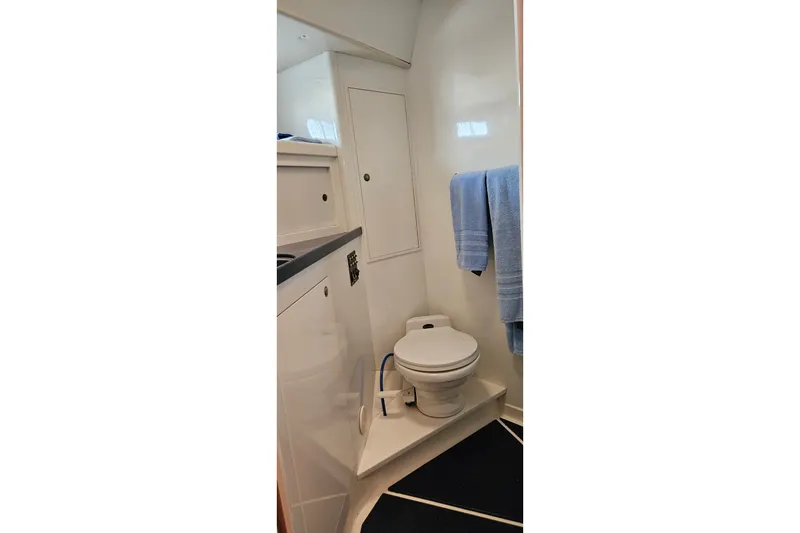 Slide: The Image of Bathroom interior of 1999 Farr Pilothouse 50 yacht, featuring a toilet and blue towels. - 14