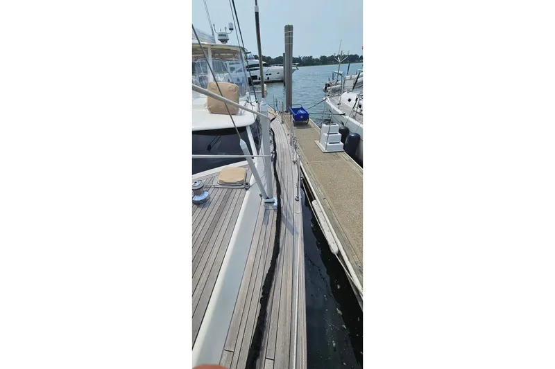 Slide: The Image of 1999 Farr Pilothouse 50 yacht docked at marina, showcasing sleek deck design. - 25