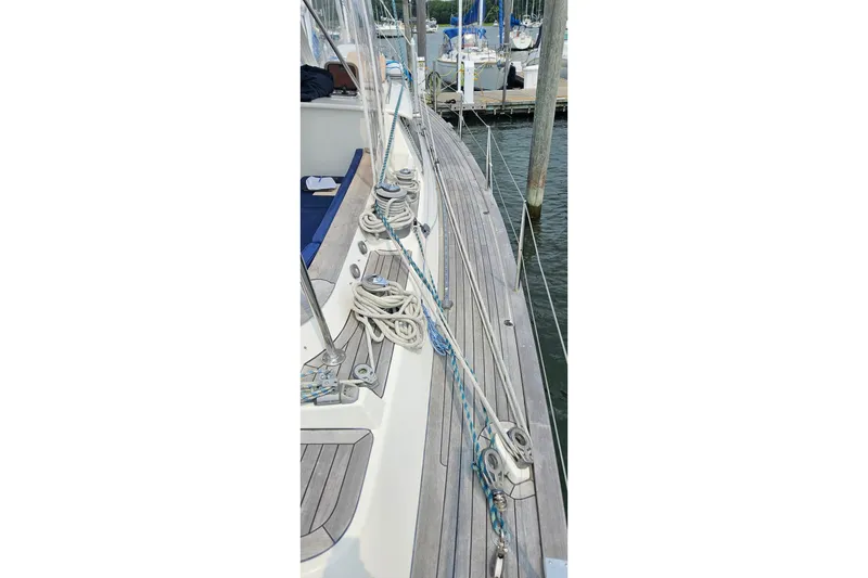 Slide: The Image of 1999 Farr Pilothouse 50 sailboat deck with ropes and fittings at a marina. - 24