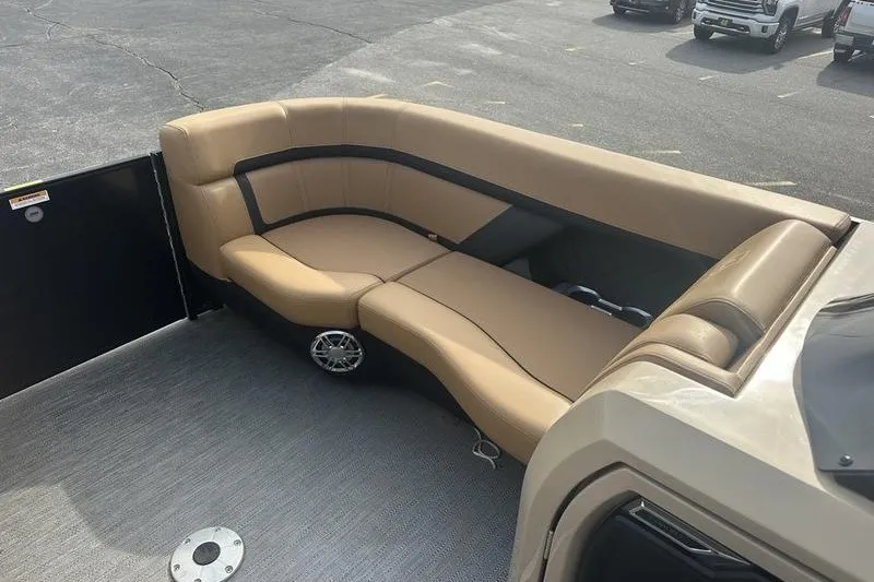 Slide: The Image of 2024 AquaPatio 235 UL boat interior with tan seating and speaker system. - 18