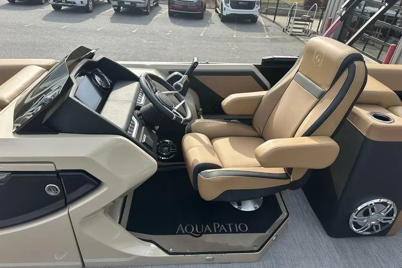 Slide: The Image of 2024 AquaPatio 235 UL boat interior with luxurious captain's chair and modern dashboard. - 19