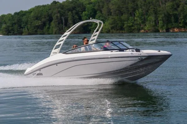 The Image of 2026 Yamaha Boats 195S cruising on a lake with lush green forest backdrop. - 1