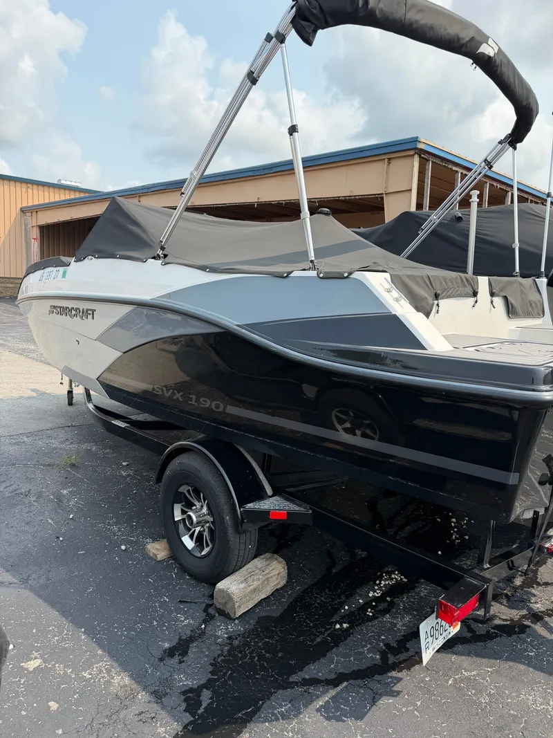 Slide: The Image of A 2021 Starcraft SVX 190 OB boat on a trailer, featuring a black and gray hull. - 13