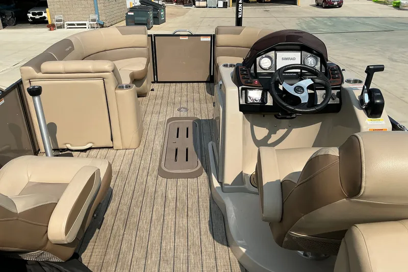 Slide: The Image of 2022 Veranda Relax VR22RC pontoon boat interior with beige seating and steering console. - 15