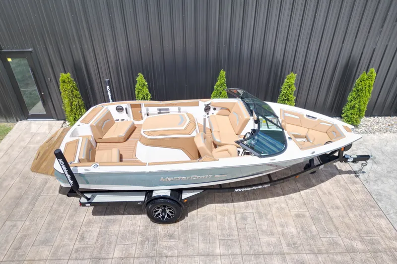Slide: The Image of 2023 MasterCraft ProStar boat on trailer, featuring sleek design and tan interior. - 20