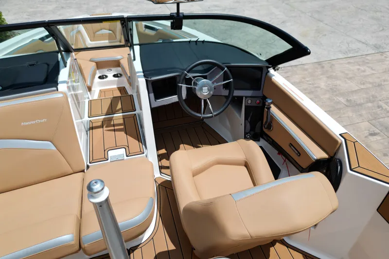 Slide: The Image of 2023 MasterCraft ProStar boat interior with tan seating and modern dashboard design. - 14