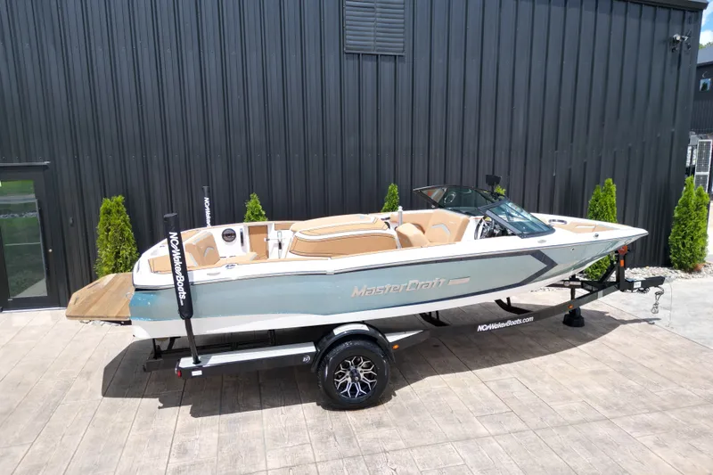 Slide: The Image of 2023 MasterCraft ProStar boat on trailer, parked outdoors near a building. - 24