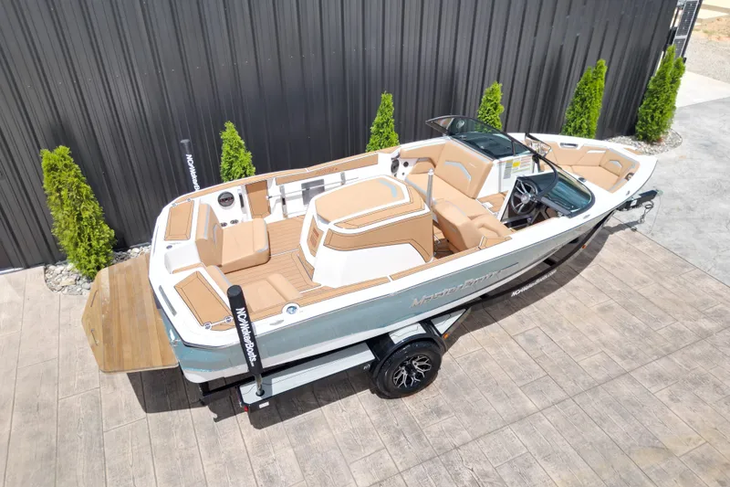 Slide: The Image of 2023 MasterCraft ProStar boat on trailer, featuring sleek design and tan interior. - 19