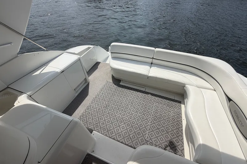 Slide: The Image of Spacious deck of 1997 Trojan 440 Express yacht with white seating and water view. - 17