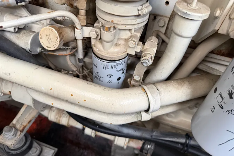 Slide: The Image of Engine components of a 1997 Trojan 440 Express boat, featuring pipes and filters. - 44