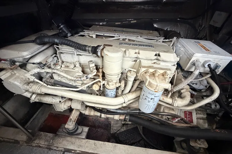 Slide: The Image of Engine compartment of a 1997 Trojan 440 Express boat, showcasing detailed mechanical components. - 42