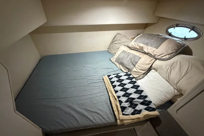 Slide: The Image of Cozy cabin interior of 1997 Trojan 440 Express yacht with bed and pillows. - 27