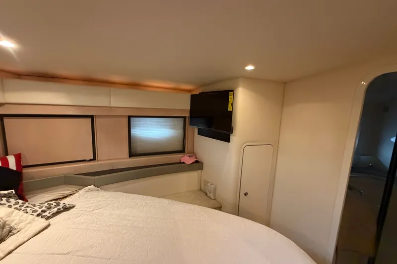 Slide: The Image of Interior cabin of a 1997 Trojan 440 Express yacht, featuring a cozy bed and modern amenities. - 33