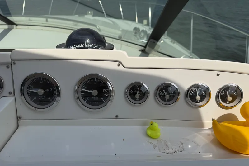 Slide: The Image of Dashboard of a 1997 Trojan 440 Express boat with gauges and rubber duck. - 15