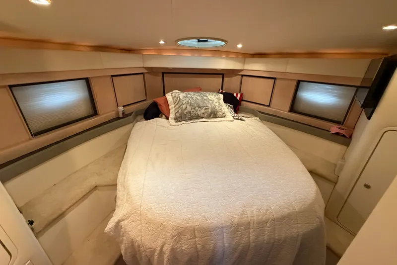 Slide: The Image of Cozy bedroom interior of 1997 Trojan 440 Express yacht with elegant bedding and soft lighting. - 32