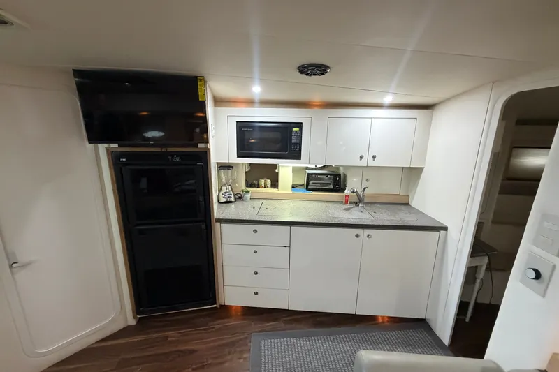 Slide: The Image of Interior of 1997 Trojan 440 Express yacht with modern kitchen amenities. - 31