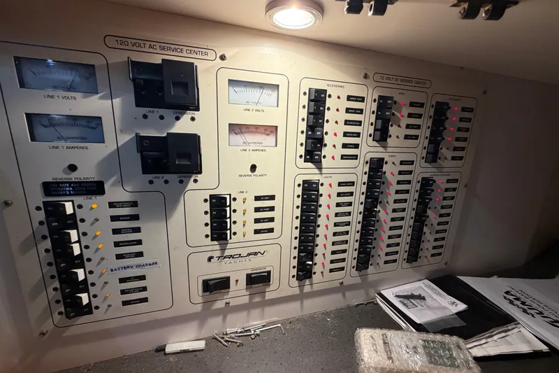 Slide: The Image of Electrical control panel of a 1997 Trojan 440 Express yacht, featuring various switches and meters. - 36