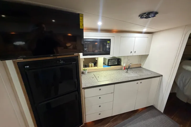 Slide: The Image of Interior of 1997 Trojan 440 Express yacht kitchen with modern appliances and sleek cabinetry. - 30
