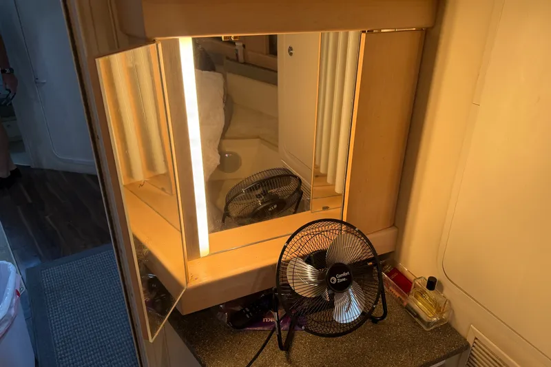 Slide: The Image of Vanity area in a 1997 Trojan 440 Express with mirror, fan, and perfume bottle. - 34