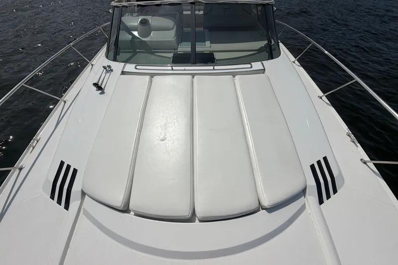 Slide: The Image of 1997 Trojan 440 Express yacht with sleek white deck and cushioned seating. - 8