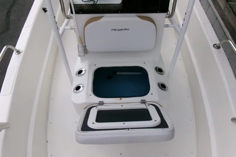 Slide: The Image of 2014 Triumph 170 CC boat interior with open storage compartment and rod holders. - 8