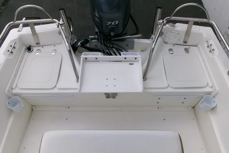 Slide: The Image of 2014 Triumph 170 CC boat interior with motor, storage compartments, and stainless steel railings. - 17